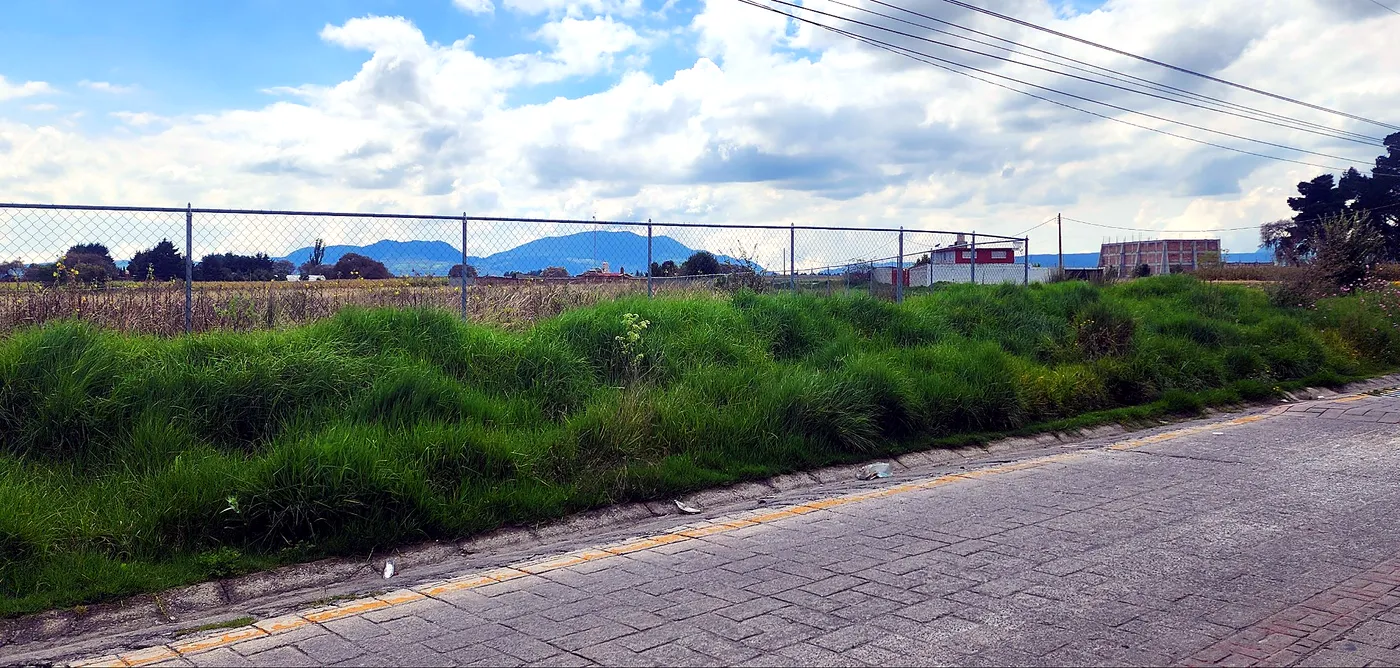 Foto real del frente del predio con los cerros al fondo